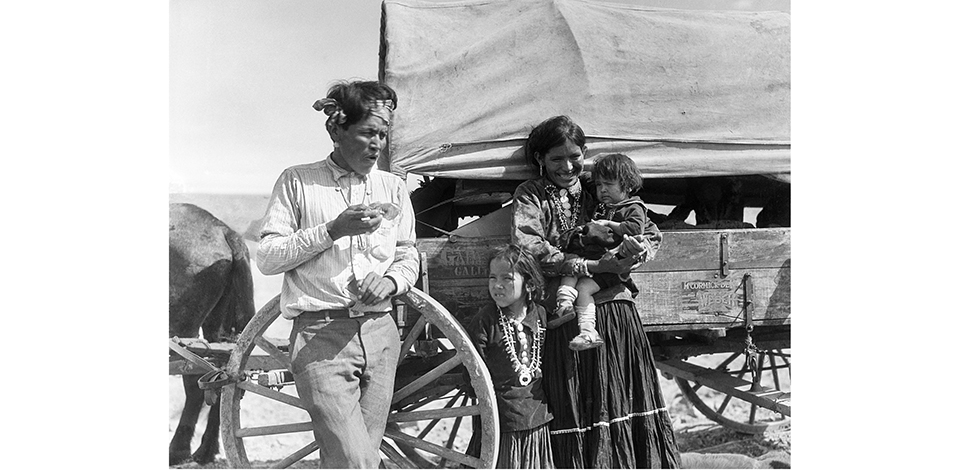 a vintage photo beside a covered wagon